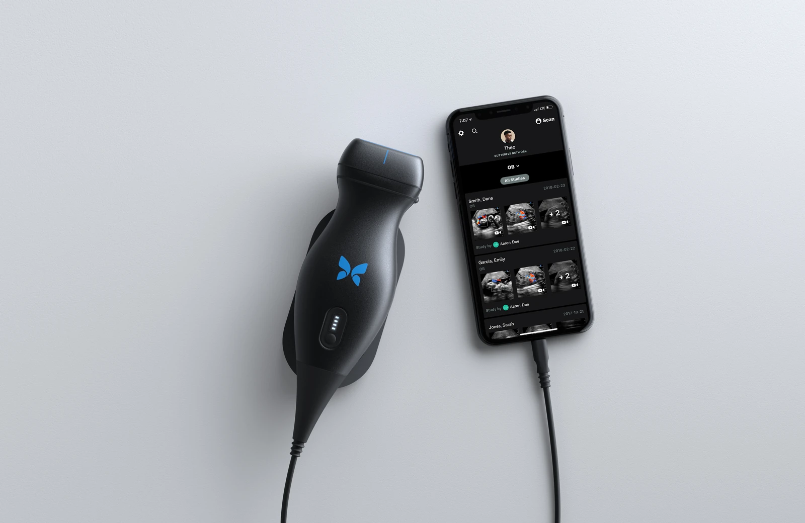 Butterfly iQ first-generation 2018 handheld ultrasound probe beside a connected phone