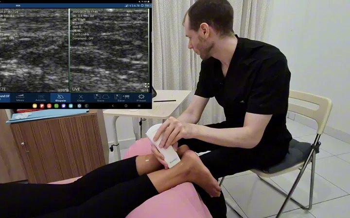 Clinician performing an ankle scan with a handheld linear ultrasound probe