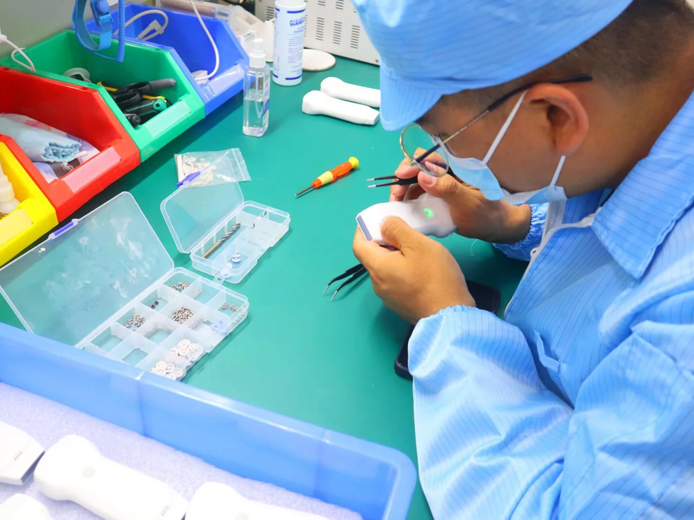 Een technicus van Suresult die een handheld echografieprobe inspecteert aan de werkbank