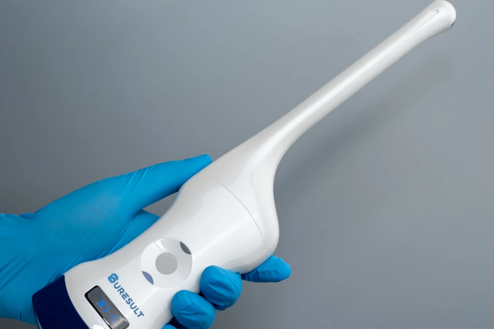 Een gehandschoende hand die de Suresult D2T endocavitaire echoprobe vasthoudt