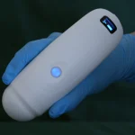 Suresult B4D-blaasscanner in een gehandschoende hand met de scankop aan de onderkant